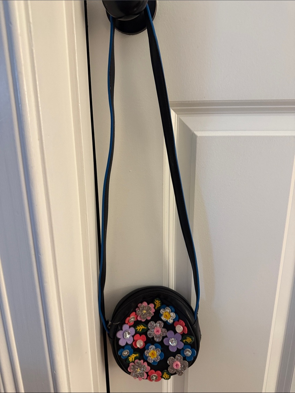 Hanna Andersson Black Round Crossbody Bag with Multicolor Floral Appliqués.
